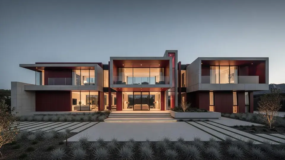 A modern villa at dusk, with warm light in the glass and a pool in front.